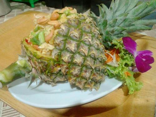a pineapple on a white plate on a table at Kohjum Seafront Resort in Ko Jum