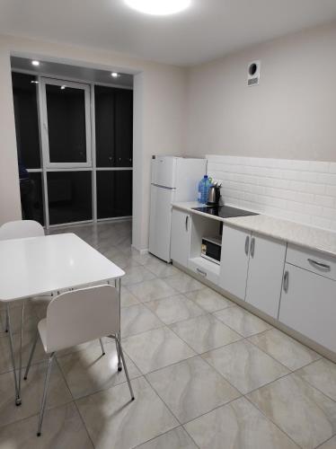 a kitchen with white appliances and a table and chairs at Апартаменти Люкс in Khmelnytskyi