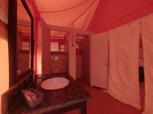 ein Bad mit einem Waschbecken und einem Spiegel in der Unterkunft Shivir Aranya - Wilderness Resort in Alwar