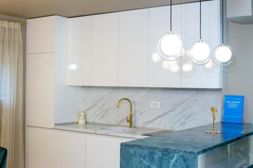 a kitchen with white cabinets and a marble counter top at Villa M&M in Budva