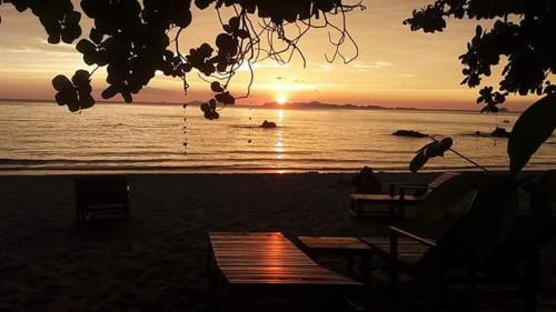a sunset on the beach with the ocean at Kohjum Seafront Resort in Ko Jum