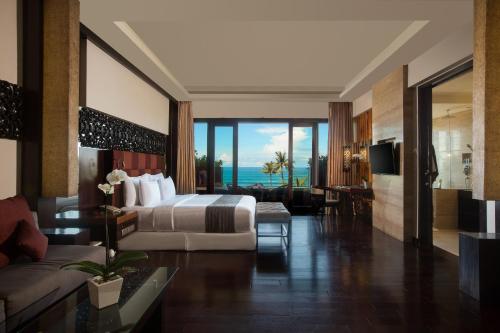 a bedroom with a bed and a living room at The Seminyak Beach Resort & Spa in Seminyak
