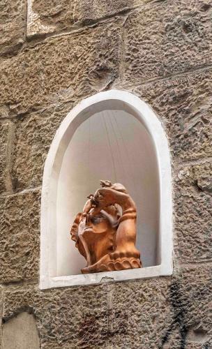 a statue in a window in a stone wall at BSJ15-Borgo San Jacopo Room in Florence