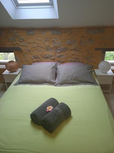 - un lit avec une couverture verte et un chapeau dans l'établissement La Lisière du Morvan, à Magny-Lormes