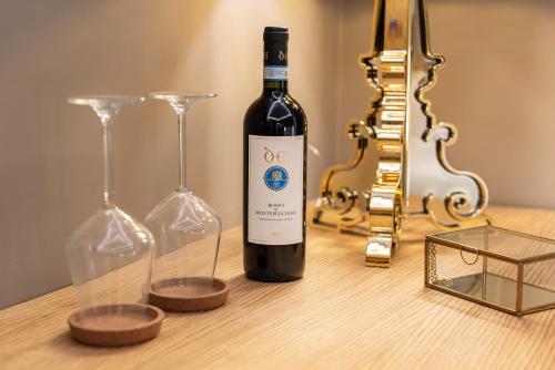 a bottle of wine and two glasses on a table at BSJ15-Borgo San Jacopo Room in Florence