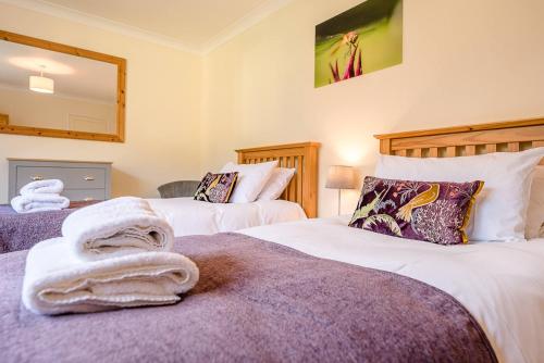 two beds with towels on them in a bedroom at The Spinney Saxtead nr Framlingham in Woodbridge