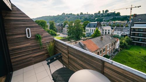 a balcony with a bench and a view of a city at Le duplex d'Albert logement d'exception à Namur in Namur