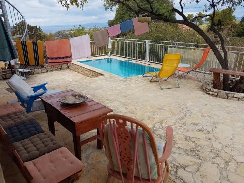 Un patio con mesa y sillas y una piscina. en Villa Masha Brač, en Bobovišća