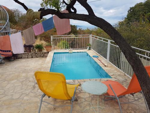 a swimming pool with chairs and a table and a tree at Villa Masha Brač in Bobovišća