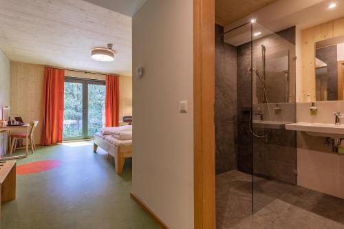 a bathroom with a shower and a sink and a bedroom at Hotel 11 Eulen in Uelzen
