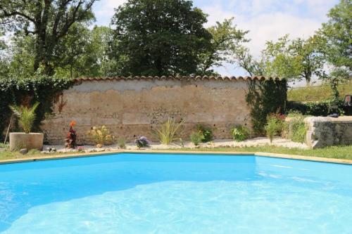 - une piscine dans une cour avec un mur dans l'établissement As seen on A New Life in The Sun - Beautiful 3 bedroom cottage with shared pool, à Montboyer