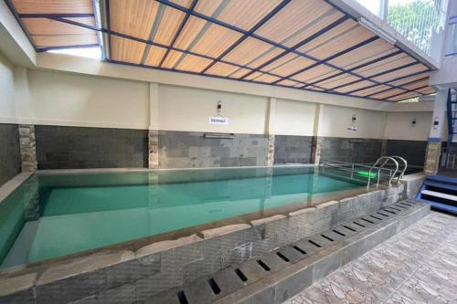 a swimming pool in a building with a swimming pool at Villa Syariah Citeko Mitra RedDoorz in Bogor