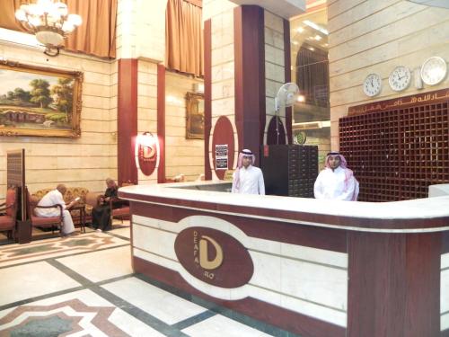 two women standing at a bar in a restaurant at Wahet Al Deafah Hotel in Mecca