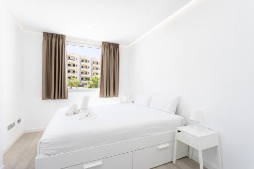 a white bedroom with a white bed and a window at Ocean Garden FL FREE WIFI in Playa Paraiso