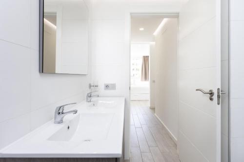 een witte badkamer met een wastafel en een spiegel bij Ocean Garden FL FREE WIFI in Playa Paraiso