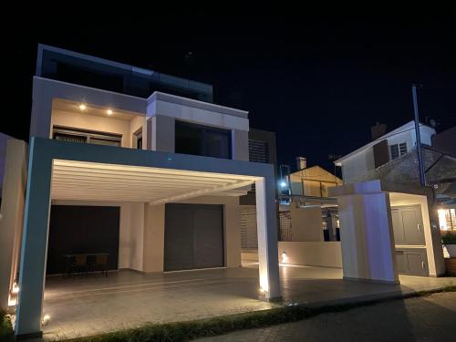 a white house with a garage at night at Vit'S sea Villa in Siviri