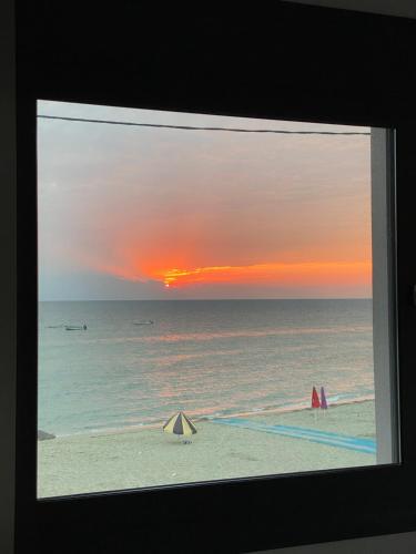 uma vista para o oceano ao pôr-do-sol a partir de uma praia em Vit'S sea Villa em Siviri