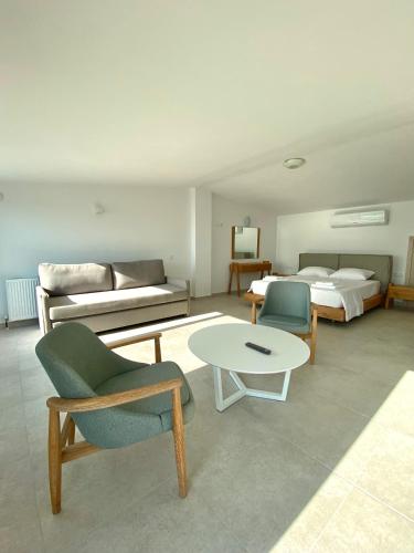 a living room with a bed and a table and chairs at Vit'S sea Villa in Siviri
