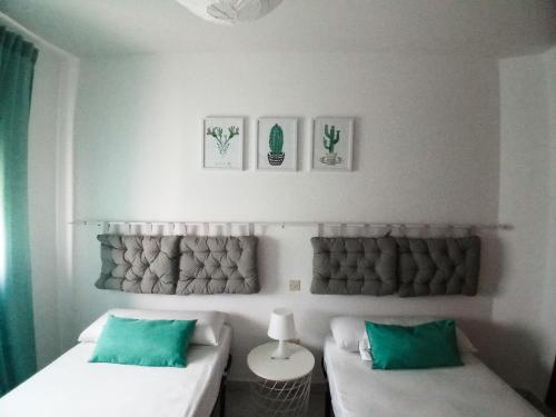 two beds in a room with green pillows at CASA PURI in Candeleda