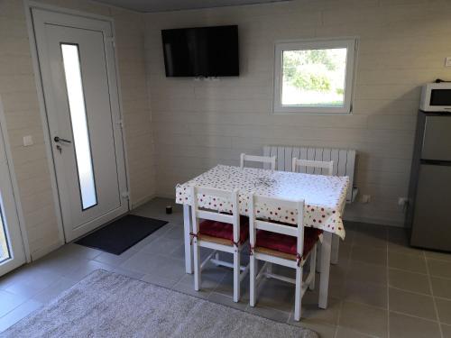 a kitchen with a table and chairs and a television at Studio Bellevue in Égletons