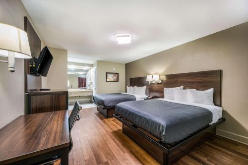 a hotel room with a bed and a desk at Econo Lodge Inn & Suites Huntsville University Area in Huntsville