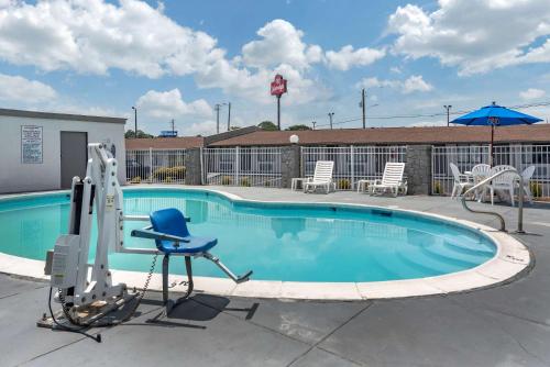 a swimming pool with chairs and a chair and an umbrella at Econo Lodge in Oxford