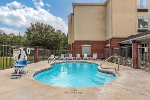 a swimming pool with a chair in a building at Comfort Inn & Suites Statesboro - University Area in Statesboro