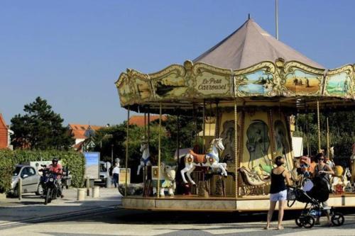 a group of people riding a carousel at a carnival at DUPLEX AVEC JACUZZI vue imprenable sur la baie de Wissant in Wissant