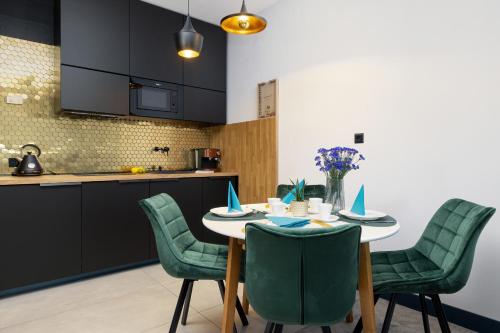 a kitchen and dining room with a table and chairs at Etna Apartments Kołobrzeg by Renters in Kołobrzeg