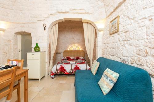 a bedroom with a bed and a blue couch at Lovely Stone House In Ostuni in Ostuni