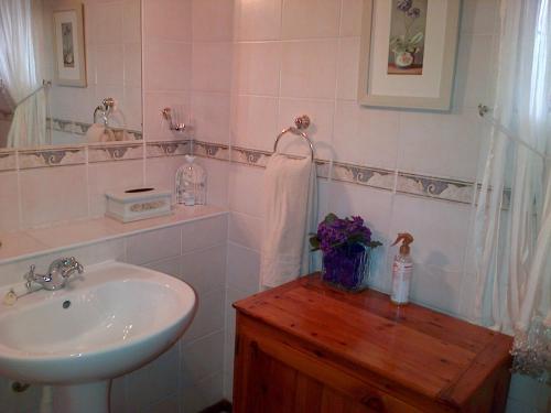 a white bathroom with a sink and a mirror at Jubilee Lodge Guest House in Johannesburg