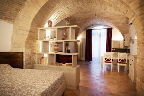 a bedroom with a bed and a table and a kitchen at Camere Capobove Assisi in Assisi