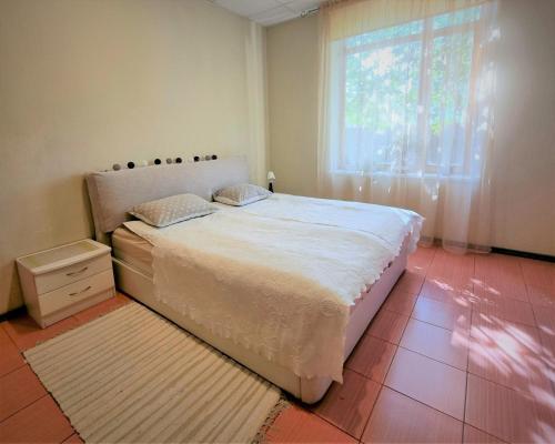 Un dormitorio con una cama grande y una ventana en Cozy Apartment Magnolia 3 Room, en Ventspils