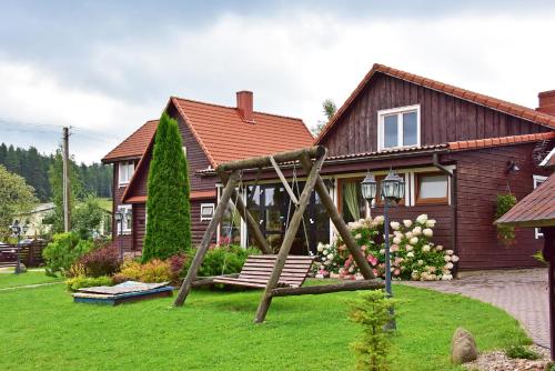 a playground in a yard in front of a house at Sodyba Sauletekis in Ignalina