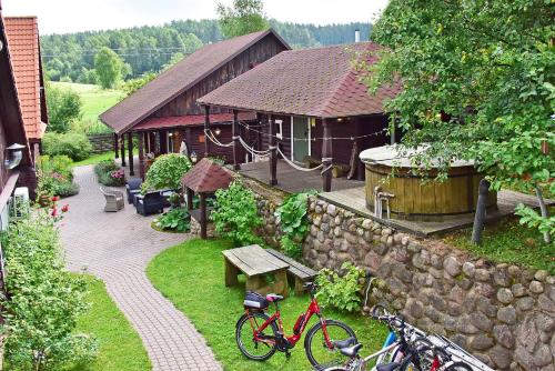 a garden with a building and a bike parked in the grass at Sodyba Sauletekis in Ignalina