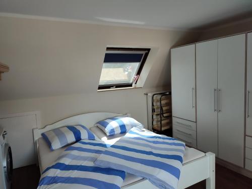 a bedroom with a bed with blue and white stripes at Wunderschöne Ferienwohnung in Brandenburg an der Havel