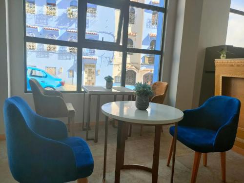 a room with chairs and a table and a window at VANCII Hotel in Chefchaouene