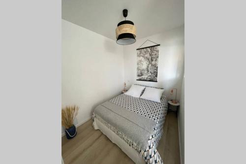 une chambre avec un lit dans une pièce blanche dans l'établissement Studio Côté Cale, à Fouesnant