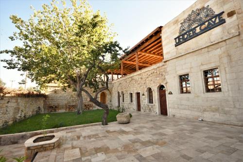 a stone building with a tree in the courtyard at Under Cave Cappadocia in Urgup