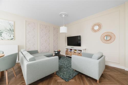 a living room with two couches and a tv at W Sercu Warszawy Apartamenty in Warsaw