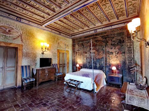 a bedroom with a bed and a tv in a room at VesConte Residenza D'epoca dal 1533 in Bolsena