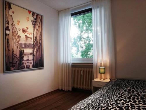 1 dormitorio con cama y ventana grande en Quartier am Campus, en Oldenburg