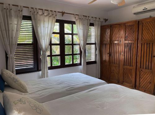 a bedroom with a large bed and two windows at Cabarete Beachfront Condos at Nanny Estate C-5 in Cabarete