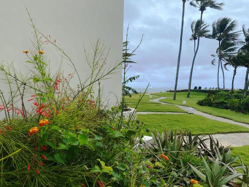 a garden with flowers and palm trees and a path at Cabarete Beachfront Condos at Nanny Estate C-5 in Cabarete