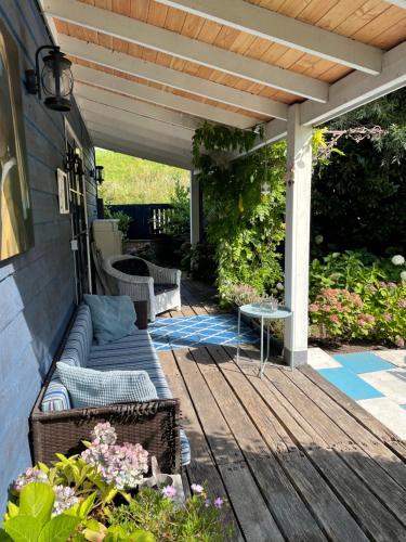 a patio with a couch on a wooden deck at Bed en breakfast Onder aan de dijk in Warder