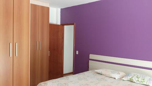 um quarto com paredes roxas e uma cama em Cobertura em Cabo Frio com vista para o Mar e para o Canal do Itajuru em Cabo Frio
