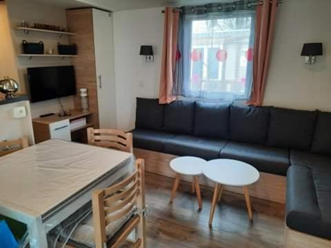 un salon avec un canapé, une table et des chaises dans l'établissement luminosa, à Litteau