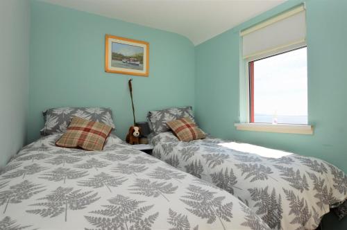 a bedroom with two beds and a window at Arthur's Seat in Innellan