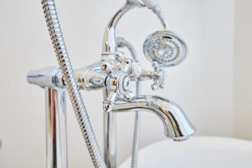 a chrome bathroom sink with a shower head at Art Deco Apartment in Gdańsk in Gdańsk