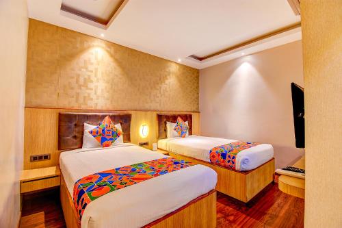 FabHotel S Comfort Inn في بانغالور: غرفه فندقيه سريرين وتلفزيون